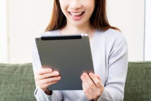 タブレットを持って喜ぶ女性