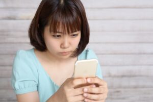 スマホを見て怒る女性